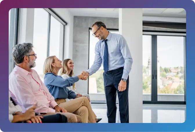 A hiring team welcoming a colleague during a meeting